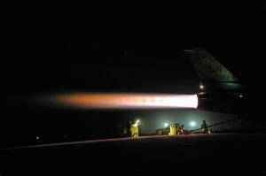 Photo showing jet engine afterburner at night.