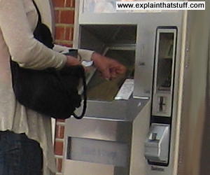 A person buys rail tickets using a touchscreen kiosk