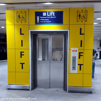 Yellow hydraulic passenger elevator at Birmingham New Street railroad station UK.