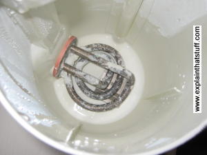 Photo of electric kettle heating element covered in limescale.