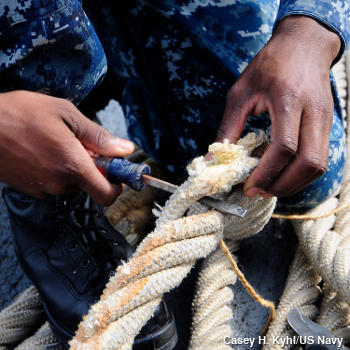 Braided Kevlar rope is repaired by a US naval operative using a screwdriver