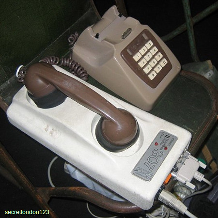 An old-style acoustic coupler modem with a telephone plugged in.