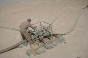 Man operating a pump in the desert