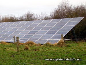 Velký nakloněný solární panel na solární farmě s oblohou v pozadí