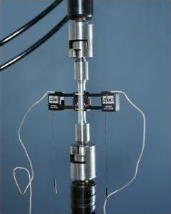 A material undergoing a tensile test in a laboratory with strain gauges attached.